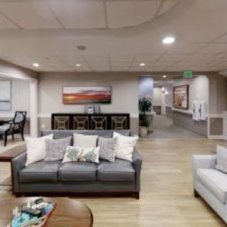 A modern living room with comfortable sofas, a coffee table, and wall artwork.