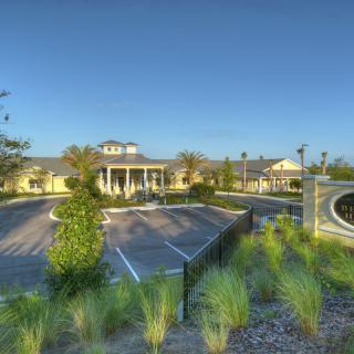A beautifully landscaped entrance to a large building, surrounded by greenery and pathways.