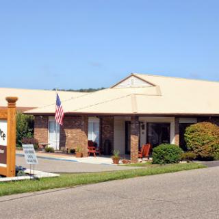 A welcoming single-story office building featuring a landscaped exterior and an American flag.