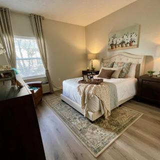 A cozy and elegantly decorated bedroom with a neatly made bed, bedside lamps, and stylish furniture.