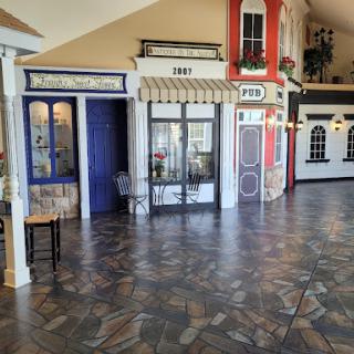 A vibrant interior featuring various storefront facades, showcasing creative architectural designs.
