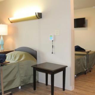 A hospital room with two beds and medical equipment.