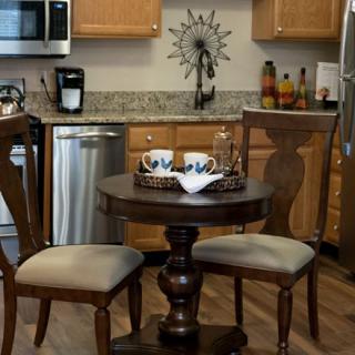 A modern kitchen with a small round table and two chairs.