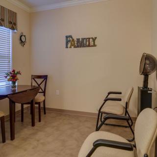 A cozy waiting room with chairs, a table, and wall decor.