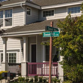 A suburban house with a street sign in front of it.