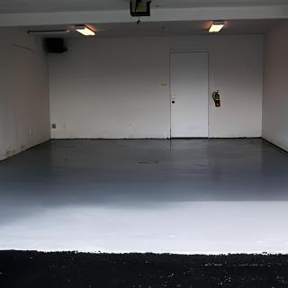 An empty, clean garage interior with overhead lighting.
