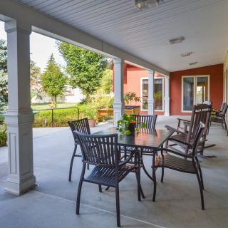 A cozy outdoor patio with a table and chairs, overlooking a landscaped garden.