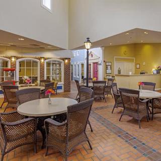 A comfortable indoor seating area with tables and chairs, designed like a small cafe or lobby space.