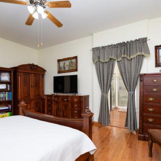 A cozy bedroom with wooden furniture and a television.