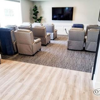 A modern theater room with multiple recliners facing a large television.