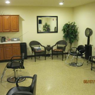 A hair salon interior with chairs, a waiting area, and salon equipment.