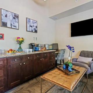 A cozy living room with a sofa, coffee table, cabinets, and wall art.