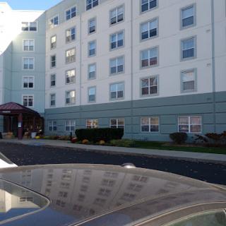A multi-story residential building with large windows and an entrance.