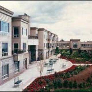 A modern residential building with well-maintained gardens and pathways.