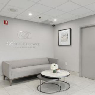 A modern waiting area featuring a grey sofa and a stylish coffee table.