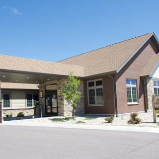A welcoming entrance to a modern building under a clear blue sky.