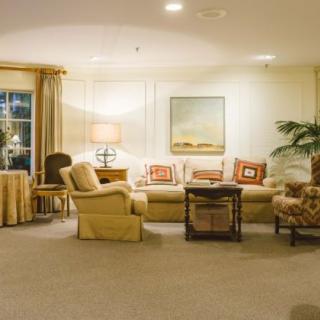 A cozy living room with a large sofa, armchairs, and warm lighting.