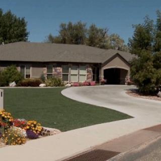 A charming home with a well-manicured lawn and colorful flower beds.