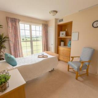 A peaceful and inviting bedroom with ample natural light, featuring cozy furniture and soothing decor.