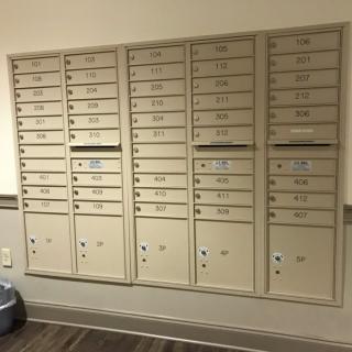 A set of wall-mounted mailboxes typically found in an apartment building.