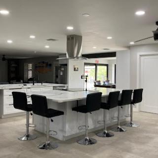 A sleek, modern kitchen featuring a large island and stylish bar stools.