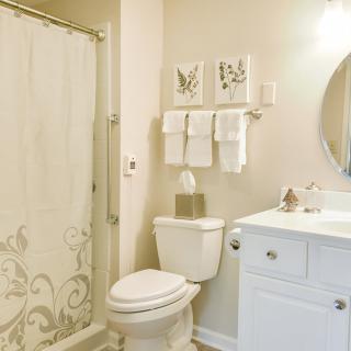 A well-organized bathroom with a sink, toilet, and shower area.