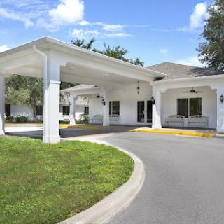 A welcoming entrance to a modern building surrounded by lush greenery.
