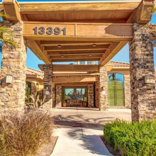 A modern entrance with stone pillars and landscaping.