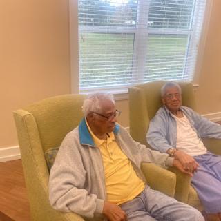 Two seniors enjoying each other's company in a cozy setting.