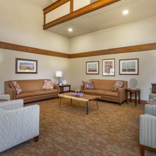 A modern lounge area featuring sofas, a coffee table, and framed artwork.