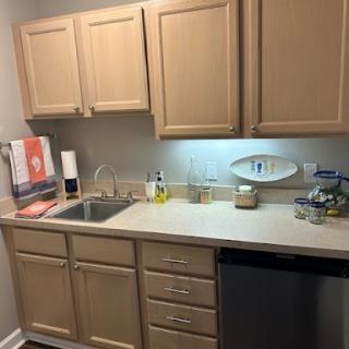 A compact kitchen featuring wooden cabinets, a sink, and modern appliances.
