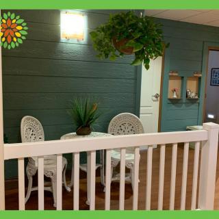 A cozy patio setup with a small table and two chairs, adorned with plants.