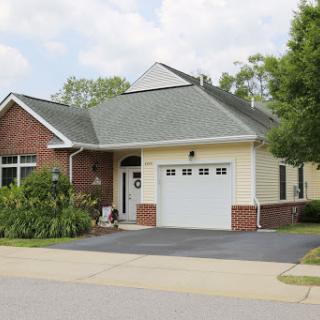 A charming suburban house with a garage and landscaped front yard.