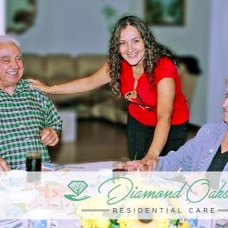 A caregiver interacts warmly with senior residents at a care facility.