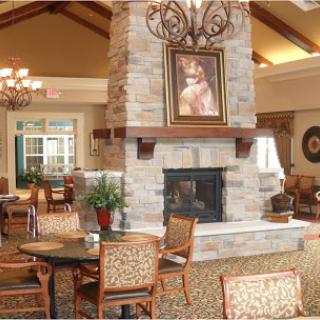 A cozy lobby area featuring a stone fireplace, comfortable seating, and elegant decor.