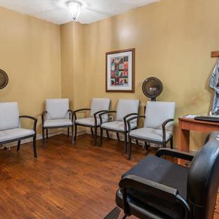 A small waiting room with several chairs and decor on the walls.