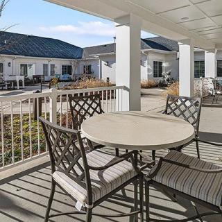 A patio with a table and chairs overlooking a residential area.