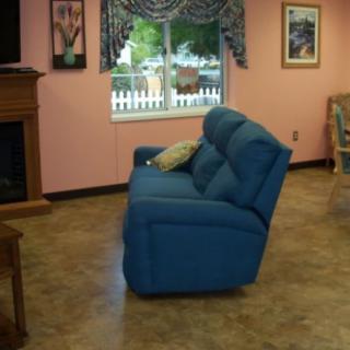 A cozy living room with a blue sofa and a fireplace.