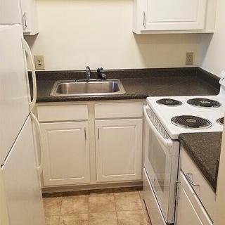 A compact kitchen with essential appliances and white cabinetry.