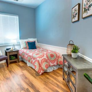 A cozy bedroom with a single bed, blue walls, and decorative elements creating a welcoming atmosphere.