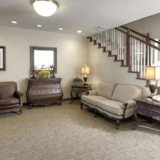 A traditional living room with classic furniture and a staircase.