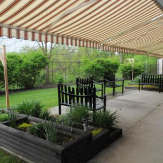 A serene outdoor garden space with seating arrangements and lush greenery.
