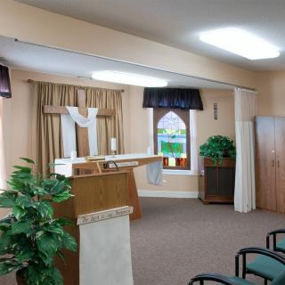 An interior view of a church featuring an altar, seating, and decorative elements.