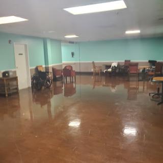 A spacious room featuring seating arrangements and polished flooring.
