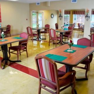 A clean and well-lit dining area with several tables and chairs arranged neatly.