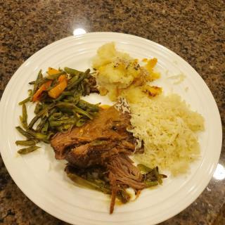 A delicious dinner plate featuring meat, rice, and mixed vegetables.