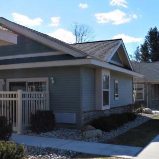 A suburban residential house with a neat front yard and clear blue sky.