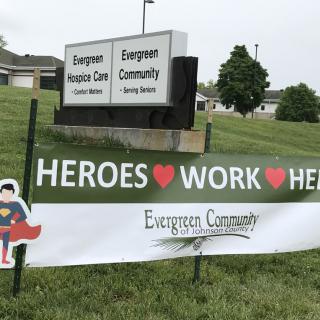 A banner outside a healthcare facility reads 'Heroes Work Here', honoring the staff.