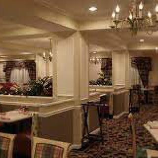 A cozy restaurant dining area with elegant chandeliers and neatly arranged tables and chairs.