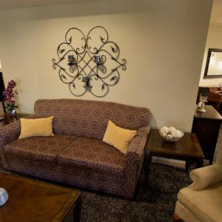 A cozy living room with a patterned sofa, decorative wall art, and a wooden coffee table.